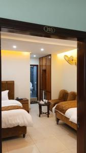 a hotel room with two beds and a living room at Osama's Room for Rent in Murree