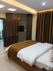 a bedroom with a large bed and a television at Osama's Room for Rent in Murree