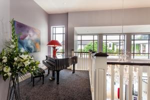 ein Flügel in einem Wohnzimmer mit Fenstern in der Unterkunft The Kenmare Bay Hotel & Leisure Resort in Kenmare