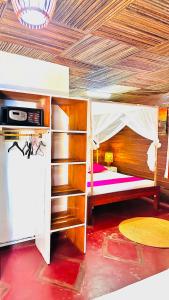 a bedroom with a bunk bed with a wooden ceiling at Bungalows des tropiques in Nosy Be +74 photos