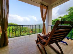 a rocking chair on a balcony with a view at Parijat-Breathtaking Sky and Hilltop view in Dapoli +5 photos
