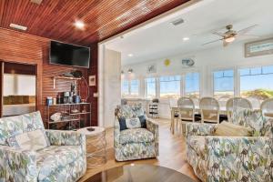 a living room with chairs and a dining room at DogFriendly Beachfront Condo in Fernandina Beach