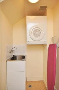 a small kitchen with a sink and a fan at Villa 2br Petit Verdot Villa located within Cypress Lakes Resort in Pokolbin