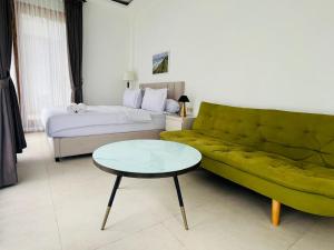 a living room with a couch and a bed and a table at Madasari Village in Madasari