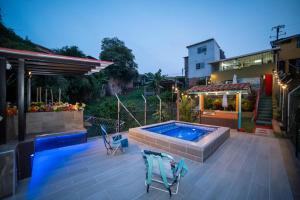 a patio with a swimming pool and two chairs at Casa de descanso Manantial del Eje in Quimbaya