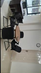 a room with chairs and a table and a clock at Caravonica apartments in Kottayam +1 photo