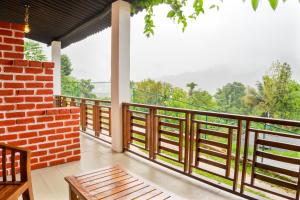 a balcony with a view of the forest at 3 Arch Villa in Ella