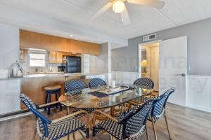 a dining room with a glass table and chairs at Nautical Oceanfront Condo in Fernandina Beach