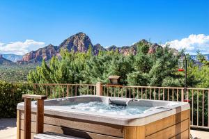 a hot tub on a deck with a view of mountains at Sedona Luxury with 75’ Lap Pool, Hot Tub & Breathtaking Vortex Views in Sedona