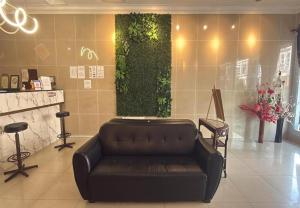 a leather couch in a lobby with a green wall at Grand City Hotel Kuantan in Kuantan
