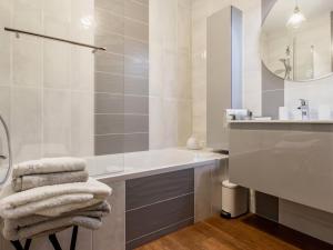 a bathroom with a tub and a sink and a mirror at Bel appartement en bord de mer avec terrasse et parking - FR-1-306-1298 in Saint-Brevin-les-Pins +8 photos