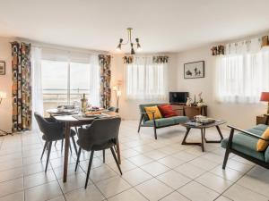 a living room with a table and chairs and a couch at Bel appartement en bord de mer avec terrasse et parking - FR-1-306-1298 in Saint-Brevin-les-Pins