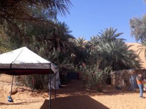 osoba stojąca na plaży z namiotem w obiekcie bain de sabl merzouga bin de sablle w mieście Merzouga