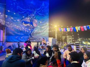 a group of people sitting in front of a stage at Urban Loft Hostel in Rishīkesh