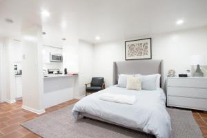 a white bedroom with a bed and a kitchen at WELL-EQUIPPED STUDIO APT - WALK TO METRO SUBWAY in Washington, D.C.