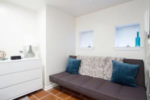 a living room with a couch and two windows at WELL-EQUIPPED STUDIO APT - WALK TO METRO SUBWAY in Washington, D.C.