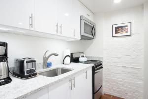 a white kitchen with a sink and a microwave at WELL-EQUIPPED STUDIO APT - WALK TO METRO SUBWAY in Washington, D.C. +10 photos