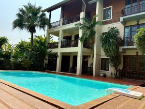 a swimming pool in front of a building at Shewe Wana Suite Resort in Chiang Mai