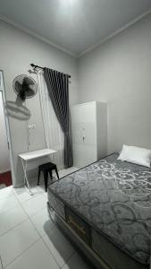 a bedroom with a bed and a table and a desk at Sultan Agung Homestay Syariah in Magelang