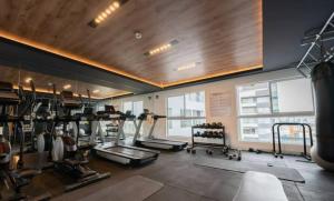 a gym with several treadmills and machines in a room at Barranco Modern Apartments with Rooftop Pool by Geko in Lima