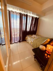 ein kleines Schlafzimmer mit einem Bett und einem Tisch in der Unterkunft Cloud Suite Tagaytay 2 in Kaybagal