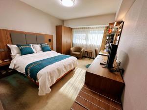 a bedroom with a bed and a desk with a television at The North Garden Hotel Beijing Wangfujing in Beijing +45 photos
