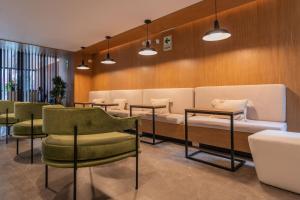 a waiting room with a couch and chairs and tables at Exclusive Mariano Santos 179 Residences by Geko in Lima +7 photos