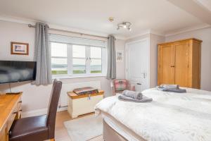 Un dormitorio con una cama y un televisor y una ventana. en James Braid Suite, en Newport