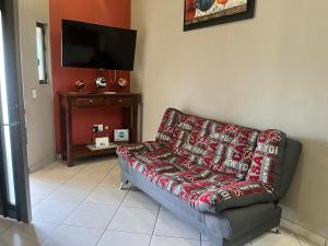 ein Wohnzimmer mit Couch und Flachbildfernseher in der Unterkunft Departamentos la Roca D4 in La Peñita de Jaltemba