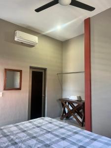 ein Schlafzimmer mit einem Bett und einem Deckenventilator in der Unterkunft Departamentos la Roca D4 in La Peñita de Jaltemba