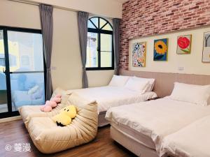 Un dormitorio con 2 camas y un sofá con un pato relleno. en Manman Homestay, en Taitung