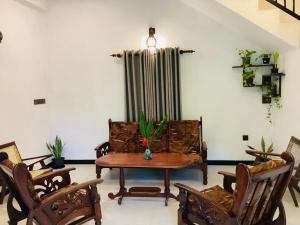 a living room with a couch and a table and chairs at Nila Villa in Galle
