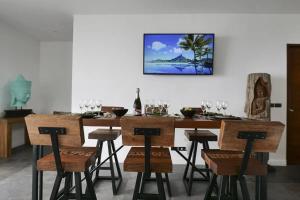 チャウエンノイビーチにあるVilla Moon Paradise 4br Infinity Pool Viewsのダイニングルーム(テーブル、椅子、ワイングラス付)
