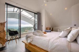 チャウエンノイビーチにあるVilla Moon Paradise 4br Infinity Pool Viewsの大きなベッドと大きな窓のある寝室 +29枚の写真