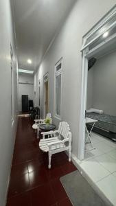 a living room with two white chairs and a table at Sultan Agung Homestay Syariah in Magelang