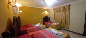 a room with three childrens beds in a room at Hotel TINAMIT in San Pedro La Laguna +12 photos