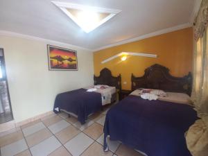 a room with two beds in a room at Hotel TINAMIT in San Pedro La Laguna