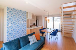 a living room with a blue couch and a table at Pool Villa Mito - Pool Villa 水戸 in Mito