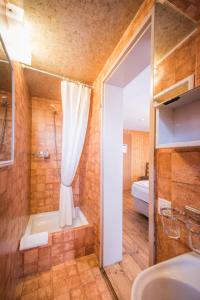 Hotel Tell and Apartments في إنترلاكن: حمام مع دش وحوض استحمام ومغسلة