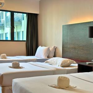 2 letti in camera d'albergo con cappelli di Ming Greenage Suite 明绿时代套房 @Kota Kinabalu 亚庇市中心 a Kota Kinabalu