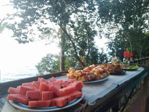 a table with two plates of watermelon and other food at Island Life Bungalows in Ko Khan