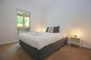 a bedroom with a large bed and a window at Houghs Cabin in Bright
