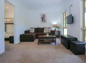 a living room with a couch and a table at Houghs Cabin in Bright
