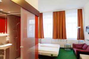 a hotel room with a bed and a bathroom at Pension Stadthalle in Vienna