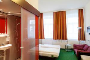 ein Hotelzimmer mit einem Bett und einem Bad in der Unterkunft Pension Stadthalle in Wien