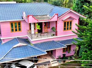 a pink house with a blue roof at Puzhayoram home stay, Palakkuli, Mananthavadi wayanad kerala in Mananthavady