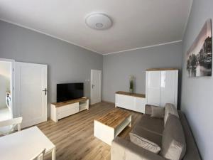 a living room with a couch and a tv at Apartament Kapitańska in Szczecin