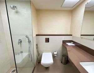 胡布利Hotel Aashray Inn的带淋浴、马桶和水槽的浴室
