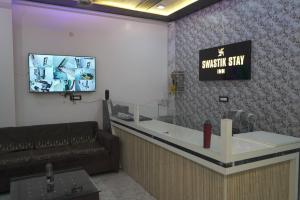 バラナシにあるSwastik Stay Innの待合室(レジカウンター、テレビ付) +2枚の写真