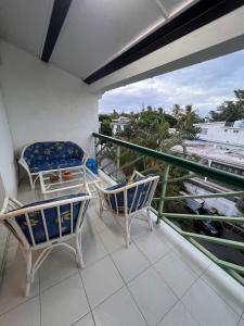 a balcony with two chairs and a table at Baobab 3 Apartment in Grand-Baie